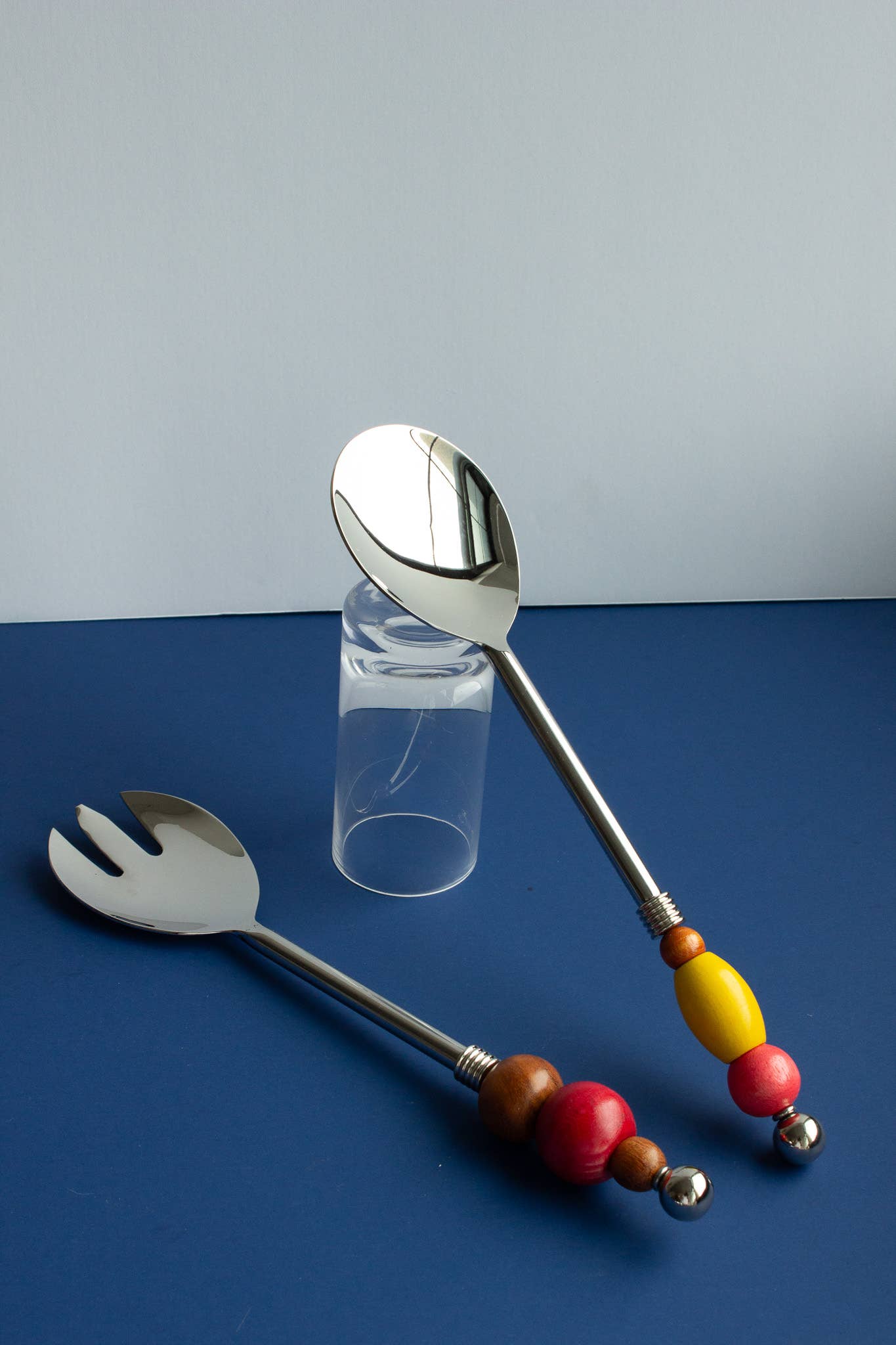 Beaded Serving Utensils by Yam, a pair of stainless steel servers with handles strung from upcycled wooden beads