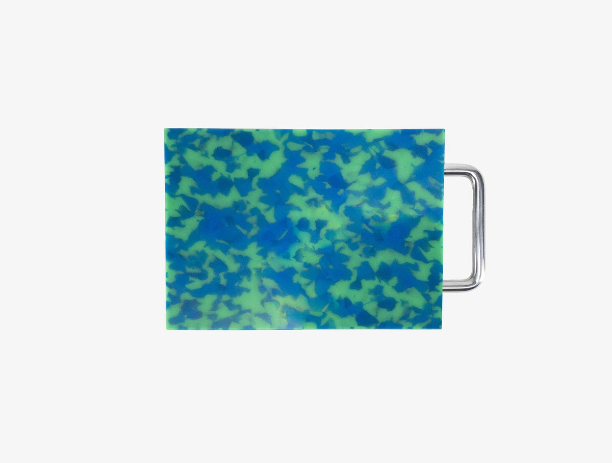 Small blue and green marbled cutting board with chrome handle on white background