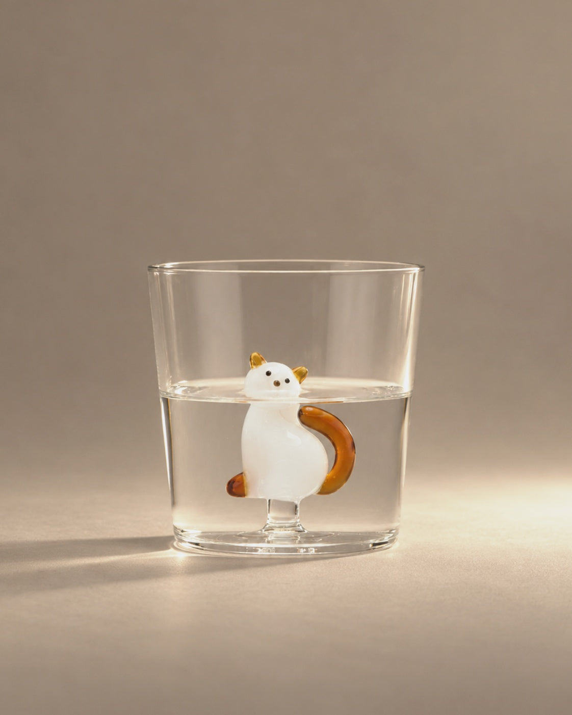 Tabby Cat Tumbler filled with water, a white cat with an amber tail inside, photographed in the Son of Rand studio