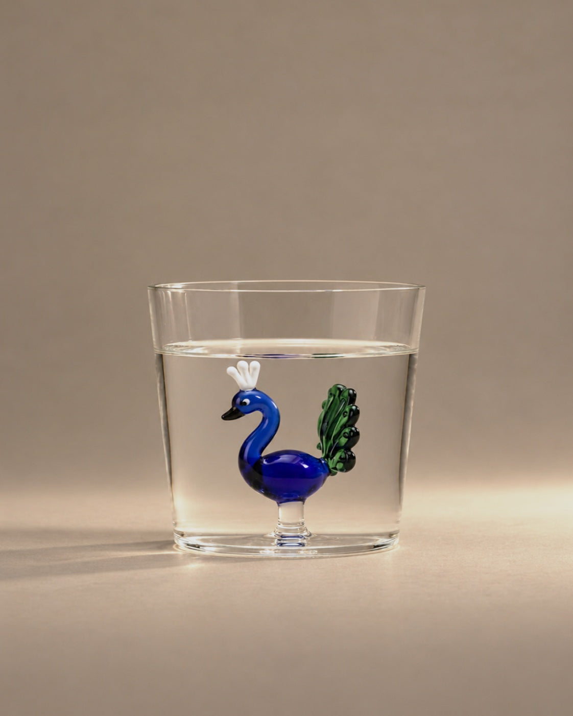 Blue Peacock Tumbler filled with water, a cobalt peacock inside, photographed in the Son of Rand studio