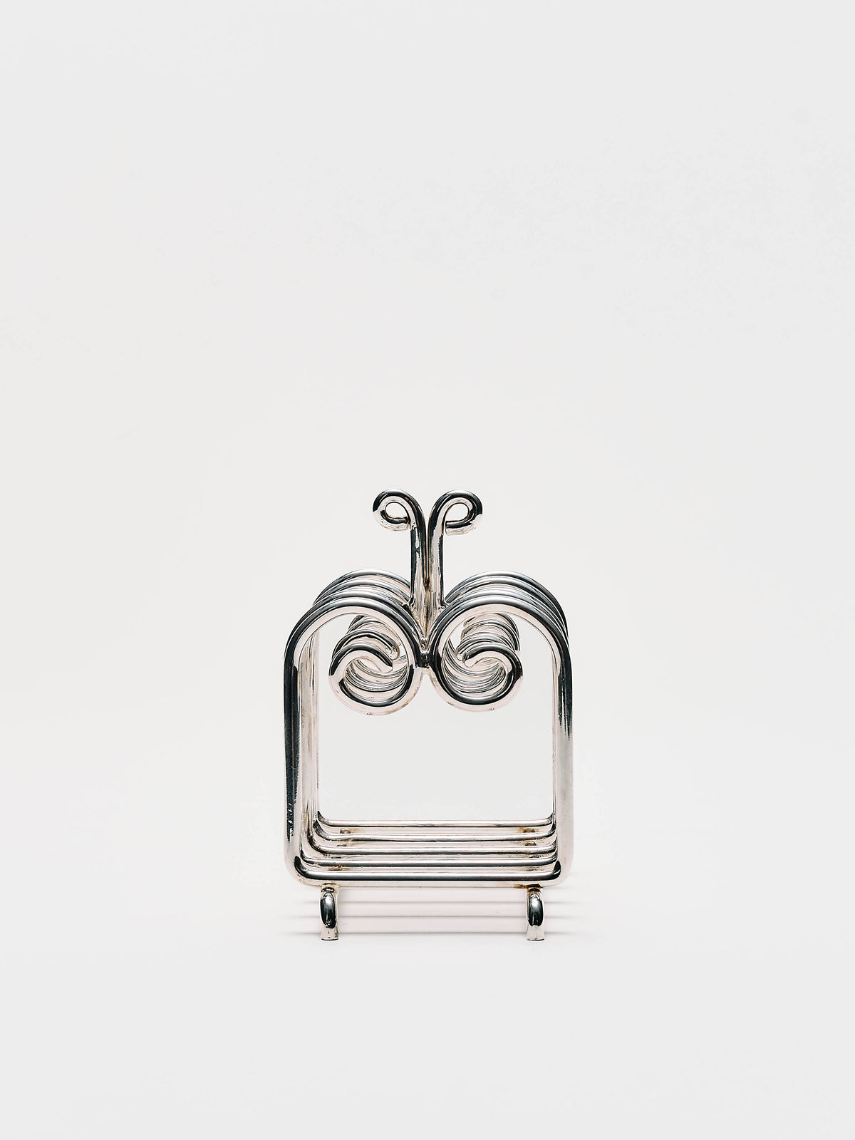 Front view of The Porter toast rack showing its symmetrical curled dividers and central handle