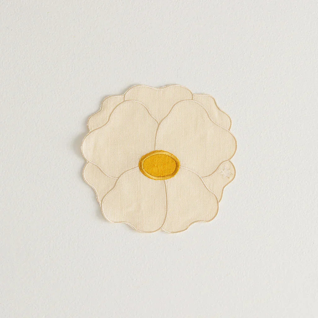 Ivory and yellow Maison Balzac wild rose napkin shaped like a flower on white background