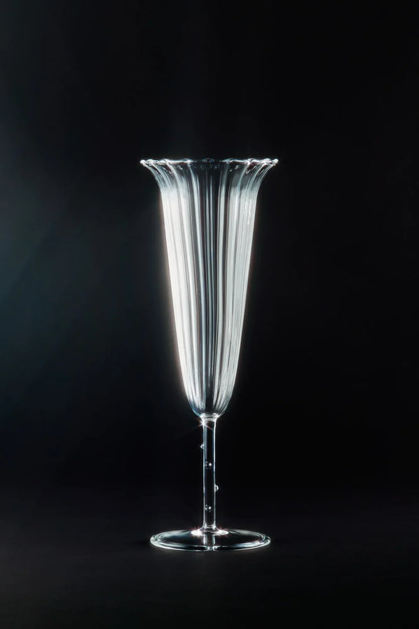 Elegant fluted glass champagne flute on black background, luxury drinkware photography