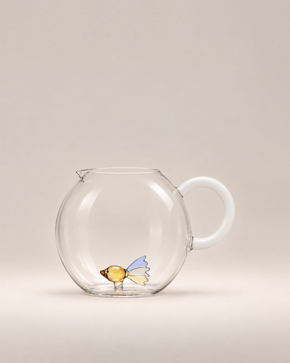 Animal Farm Fish Jug, a round clear glass jug with a milky white handle and a little glass fish inside, photographed in the Son of Rand studio