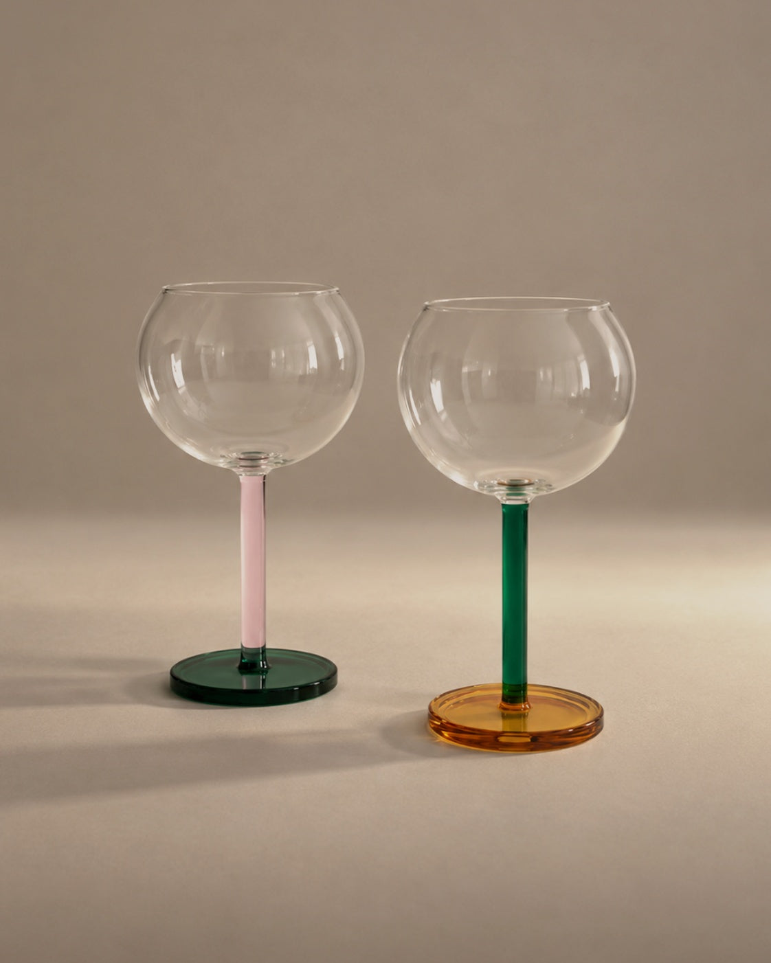 Bilboquet Wine Glasses in Golden Hour, a pair with pink and green stems, photographed in the Son of Rand studio