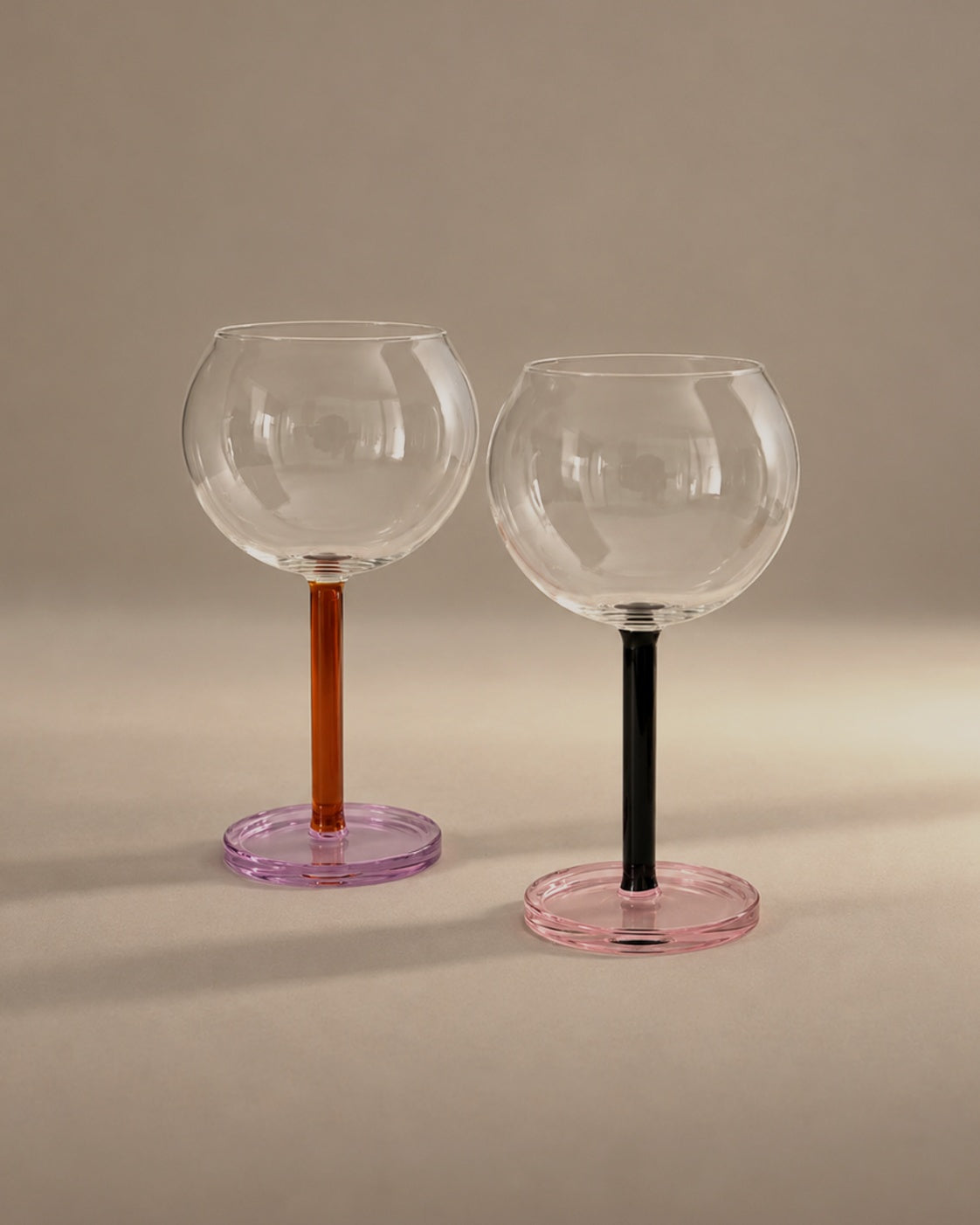 Bilboquet Wine Glasses in Twilight, a pair with amber and black stems, photographed in the Son of Rand studio