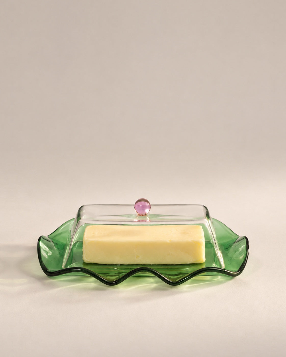 Everything Nice Butter Dish, a wavy green glass plate with a clear lid and pink knob, photographed in the Son of Rand studio