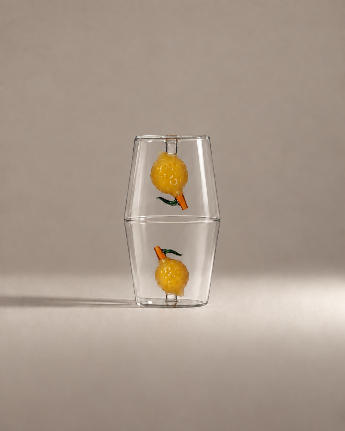 Fruit Stand Gift Set with two lemon glass tumblers stacked rim to rim on a warm greige background