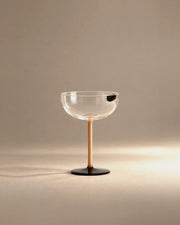 L'Espresso martini glass with amber stem and black foot, studio photo