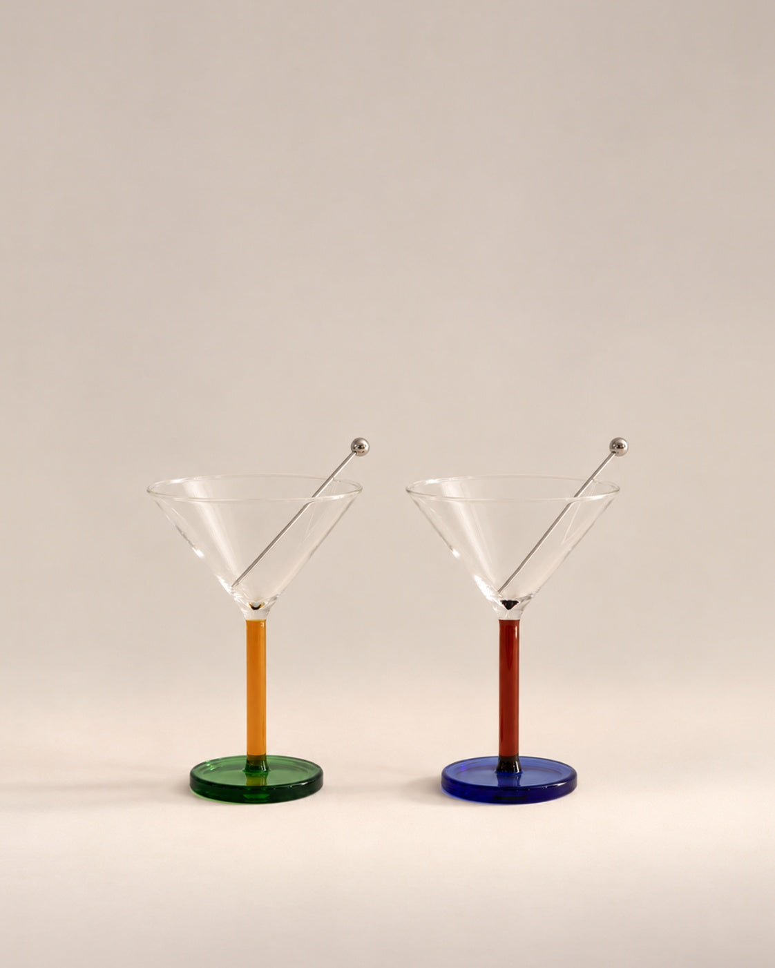 Pair of Piano cocktail glasses in Dizzy with orange and red stems on green and blue feet, photographed in the Son of Rand studio