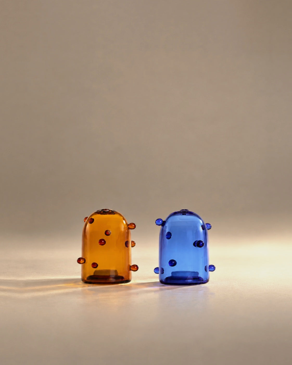 Pomponette salt and pepper set in amber and cobalt glass, studio photo