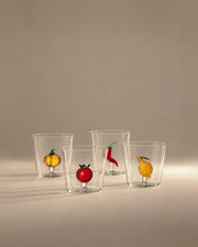 Four glass tumblers with a pumpkin, tomato, chili and lemon inside, photographed in the Son of Rand studio