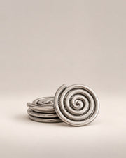 Set of four silver spiral coasters, three stacked and one standing, photographed in the Son of Rand studio
