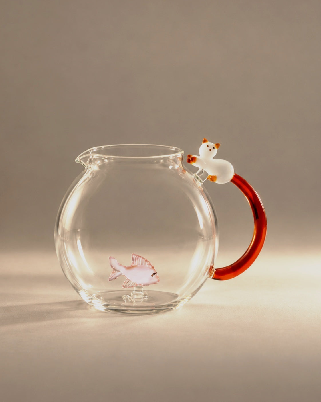 Cat and Fish Jug, clear glass with a white cat and amber tail handle, studio photograph