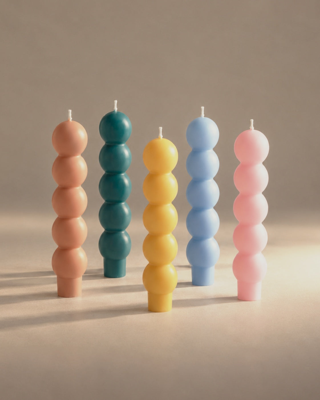 Volute candles in sable, teal, miel, sky and pink, photographed in the Son of Rand studio